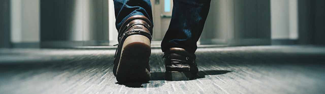 man loopt met zijn schoenen over een schoonmaakmat