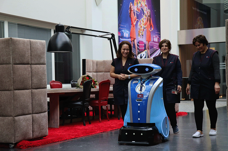 3 schoonmakers verwelkomen een schoonmaakrobot in hun team